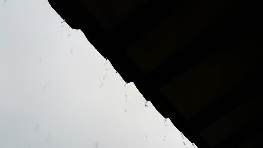 Silhouette of raindrops falling from the roof of the house | Shutterstock HD Video #1101250827