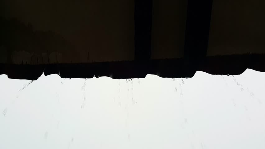 Silhouette of raindrops falling from the roof of the house | Shutterstock HD Video #1101250829