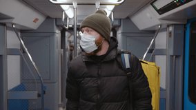 Hand-held camera. Portrait of a courier in a medical mask in the subway