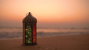 Traditional Ramadan Lantern Lamp on the beach during sunset, Ramadan and Eid Greetings Video with Copy space, 2023 Islamic concept video