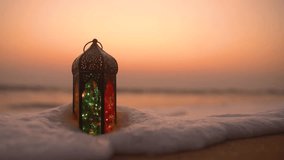 Traditional Ramadan Lantern Lamp on the beach during sunset, Ramadan and Eid Greetings Video with Copy space, 2023 Islamic concept video