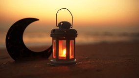 Islamic concept video, Traditional Ramadan Lantern Lamp with Crescent moon shape on the beach, copy space for greeting text