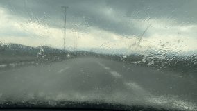 heavy rain on the road drops on the windshield