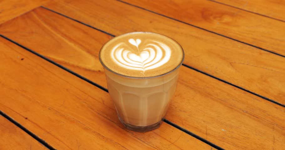 Man take glass of latte with picture on foam from the table, close up slow motion shot. Coffee drink with short-living art on neat foam at top, a popular attraction for cafe customers | Shutterstock HD Video #1101261935