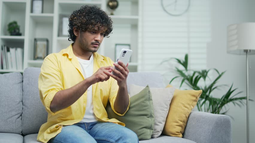 Amazed handsome man receiving sms message offer opportunity arabian happy man reading good news in smartphone Excited overjoyed indian male winner celebrating success mobile phone victory notification Royalty-Free Stock Footage #1101262121
