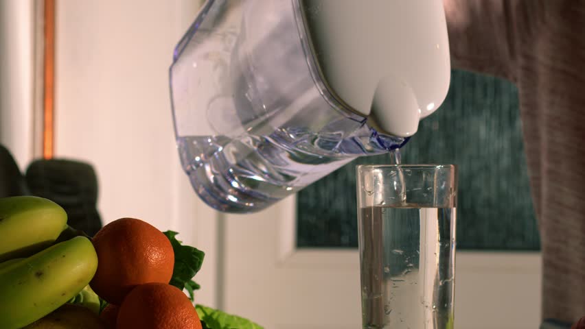 Woman with glass of filtered water and fresh fruit medium shot slow motion 4k selective focus | Shutterstock HD Video #1101263031