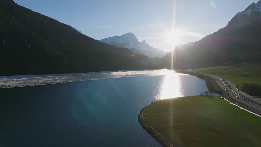 Aerial view of the snow rocky cliffs with forest by the lake. Dramatic and picturesque scene. Location place Bachalpsee in Swiss alps, Grindelwald valley, Bernese Oberland, Europe. Beauty world.