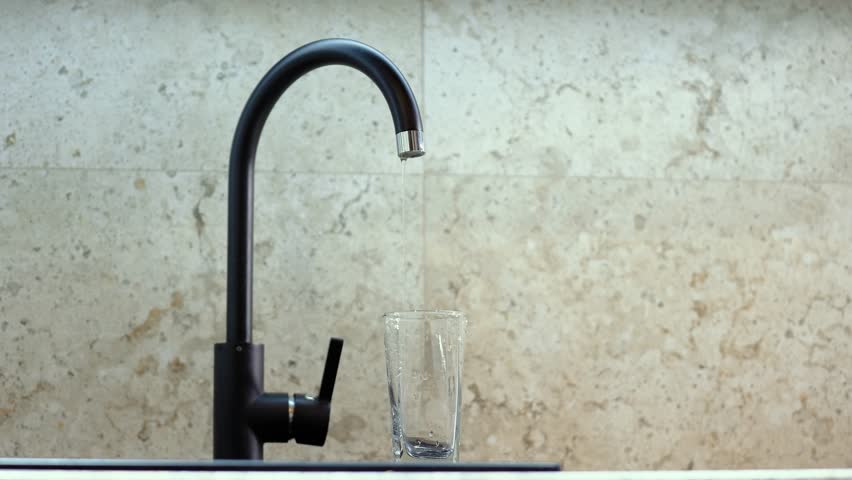 Clean drinking water from the tap. Slow motion. A glass of water, a beautiful frame. Concept: thirst, saving resources, water use, utility prices, flushing money down the drain. | Shutterstock HD Video #1101266219