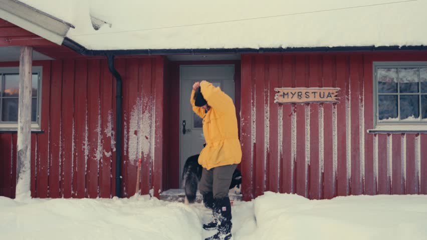 European Man Outside The Cabin Untying Hair And Puts On Beanie Hat In Winter. full shot