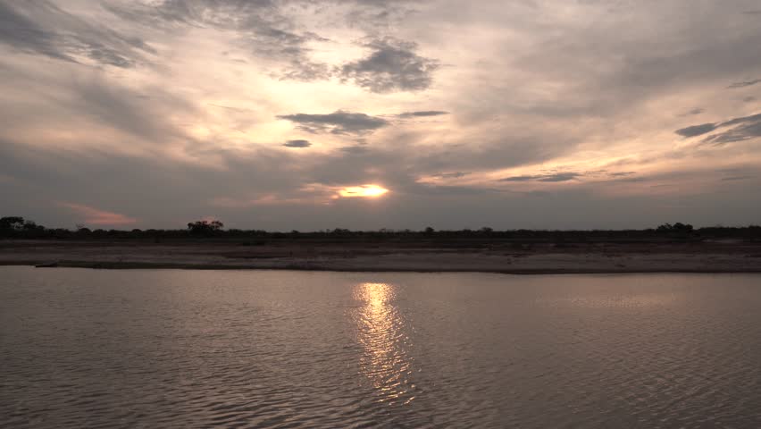 Panorama view of the river under a dramatic sunset sky with beautiful clouds. View of the landscape reflection in the water. 