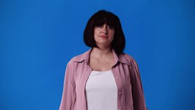 4k video of one woman with crossed hands on blue background.