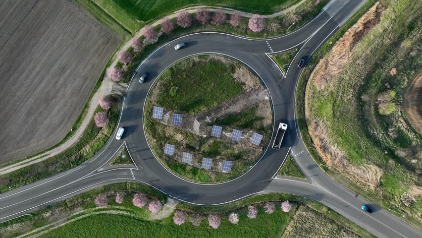 Time lapse video: roundabout traffic of cars and trucks on the circle ring road aerial top view Royalty-Free Stock Footage #1101280817