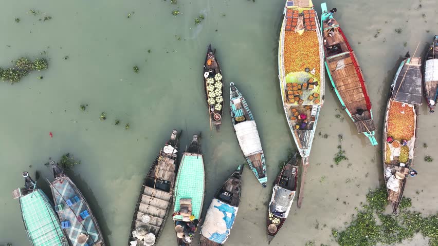 Aerial view of people trading with fruits and vegetables on boats along the river in Dhaka, Bangladesh.