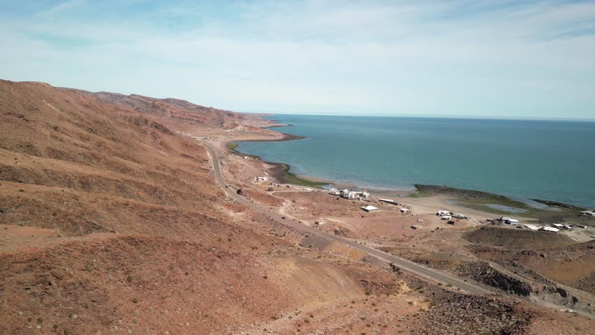 High aerial over remote coastal villages in Baja California along Mex 5 highway in red desert landscape