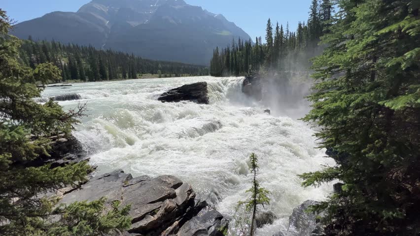Majestic Athabasca Falls cascading down the rocky cliffs of Jasper National Park, Alberta, Canada. Beautiful view of Athabasca Falls and the powerful waters rushing through its narrow gorge