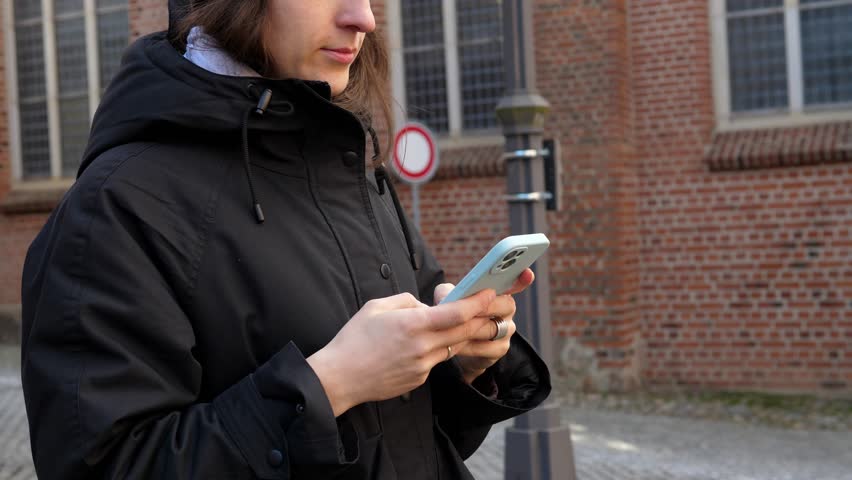 The girl takes her mobile phone out of her pocket and answers the message