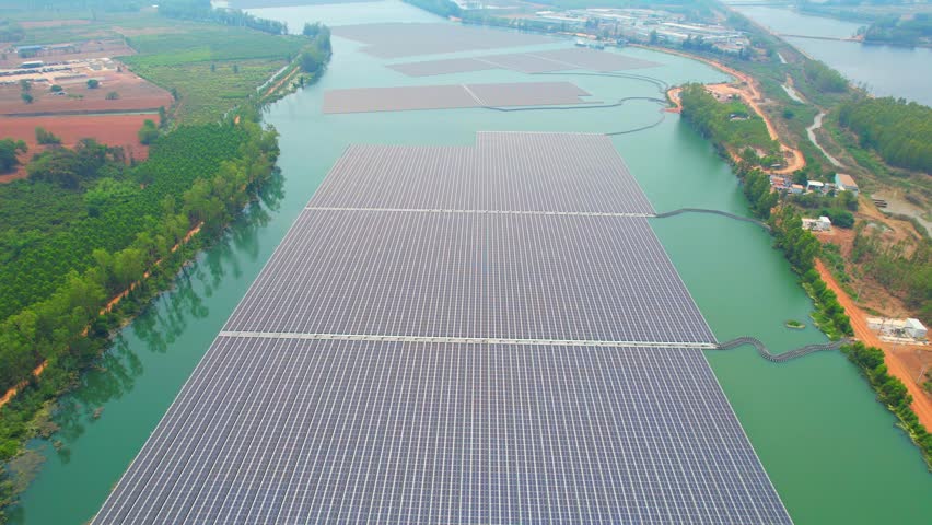 The concept of solar panels floating on water is an innovative and environmentally-friendly solution for generating clean energy in areas with limited land availability. aerial view. 4K Drone

