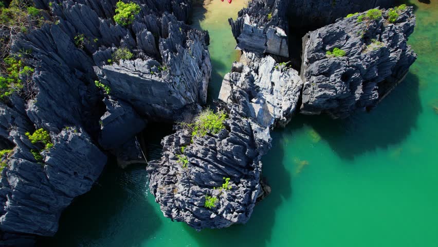Limestone peaks rise, casting intricate shadows on the rippling sea below. standing tall in the middle of the ocean, creating a maze of hidden lagoons, caves, and beaches. (Satun Province, Thailand)
