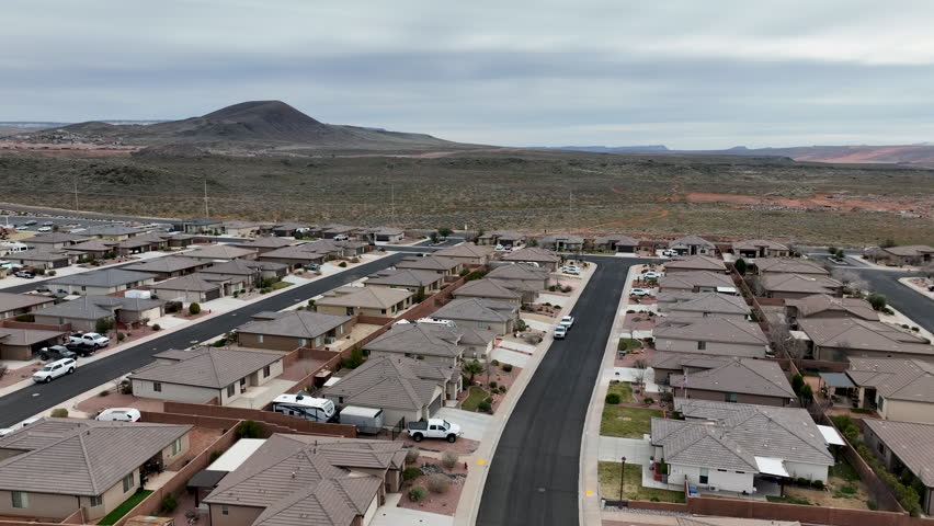 Aerial home residential neighborhood street Hurricane Utah. Aerial Subdivision residential homes. Desert mountain valley. Schools, parks, church and public streets and roads. Housing boom economy.