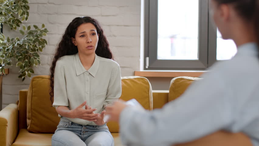 Personal therapy. Young stressed upset woman talking to psychotherapist, telling her life and professional problems, specialist taking notes at office, selective focus Royalty-Free Stock Footage #1101297721