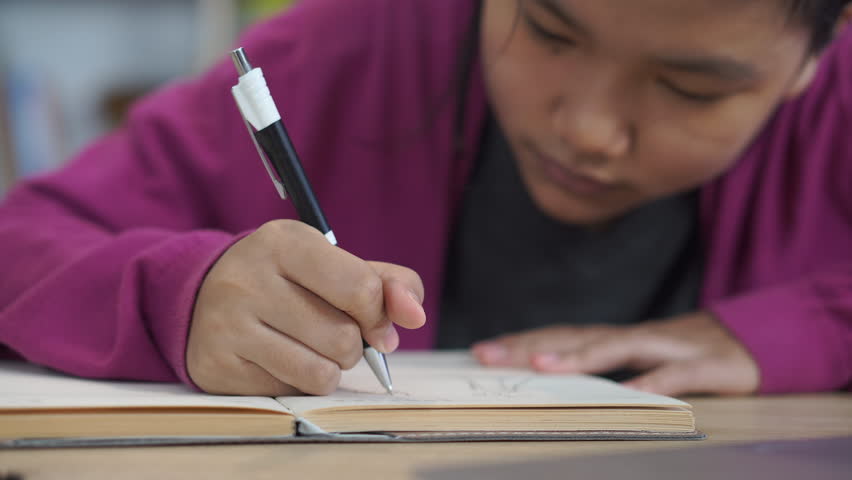 Asian elementary Children Writing Letter on diary book. Kid learn and work, read book at home. Cute Child doing and study for exam and do homework. Little Child happy and smile. Education Concept. - Powered by Shutterstock - Get 15% off with code: PIKWIZARD15
