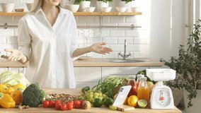 a beautiful woman in a white casual shirt enjoys cooking healthy food in her kitchen, a contented woman at home in the kitchen.