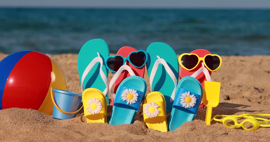 Beach flip-flops on yellow sand against blue sea and sky background. Summer vacation concept. Slow motion | Shutterstock HD Video #1101302305