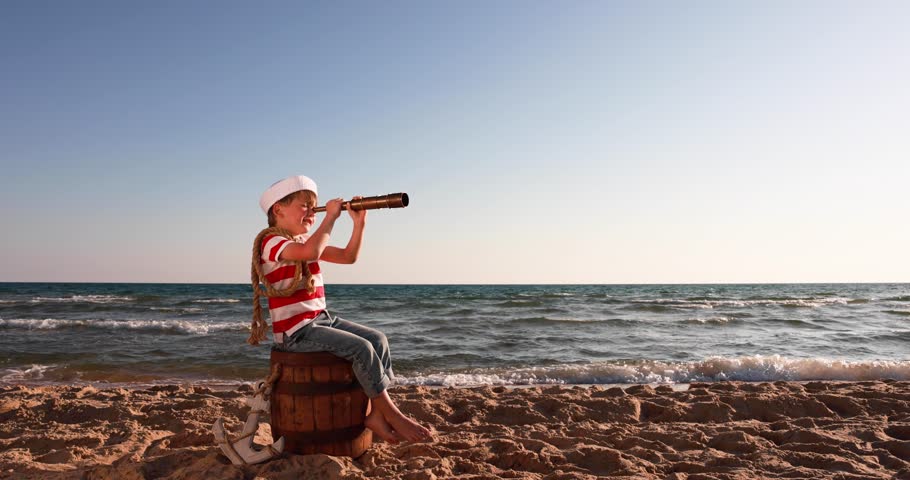 Happy child pretend to be sailor. Kid having fun at beach. Boy looking through spyglass. Summer vacation and travel concept. Slow motion | Shutterstock HD Video #1101302307