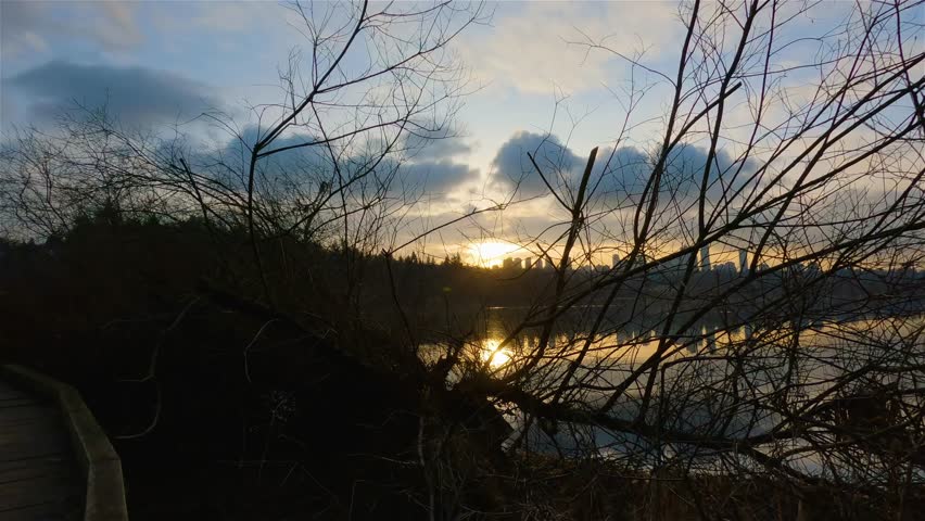 Trail by Peaceful Lake in the modern city, Deer Lake Park. Burnaby, Vancouver, BC, Canada. Colorful Winter Sunset Sky. Slow Motion Cinematic Pan.