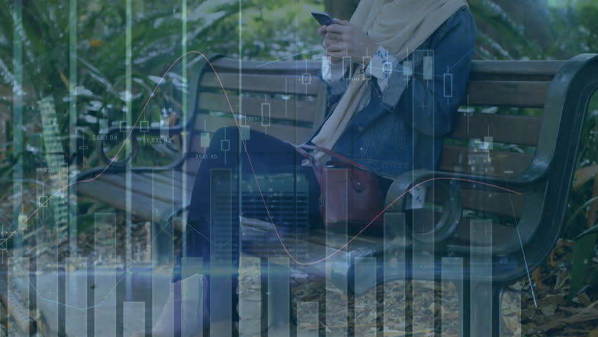 Animation of financial data processing over biracial woman in hijab using smartphone in park. Global connections, business, finances, computing and data processing concept digitally generated video.
