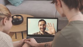 Caucasian military man video chatting with beloved wife and little daughter on laptop while away from home in army