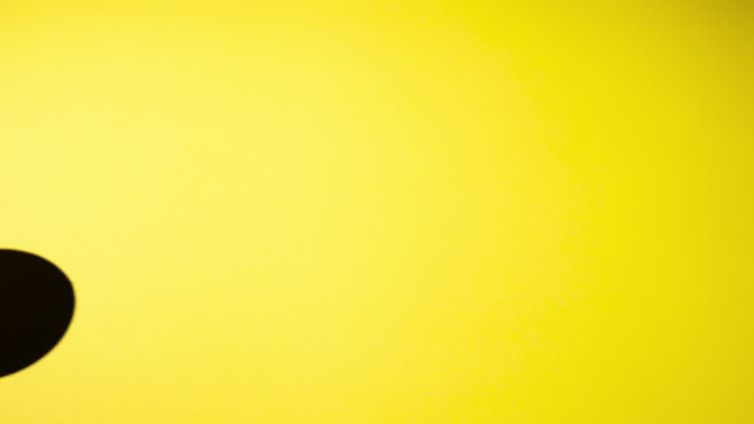 Cardboard brown cup on a yellow background. Stop motion.