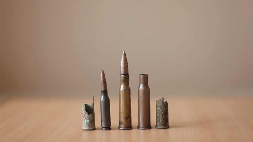 Old rusty bullets and cartridge cases from a machine gun lie on the table. Collection of military cartridges.