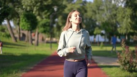 Gorgeous slim Caucasian young woman running in slow motion in sunshine leaving. Dolly shot portrait of confident motivated beautiful sportswoman jogging training outdoors on sunny day - Powered by Shutterstock - Get 15% off with code: PIKWIZARD15