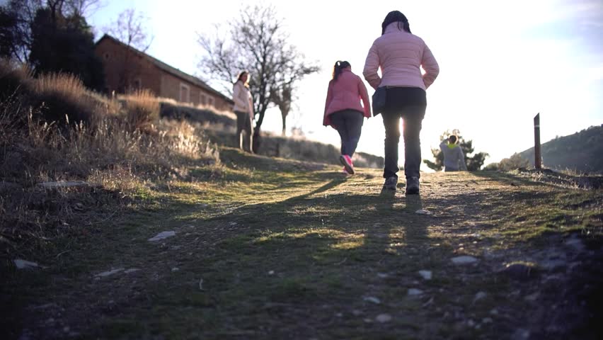 Hikers walking in group at mountain forests and pathways. Group of people hiking in hill landscape. Healthy sportsman exercising trekking walking at the mountain