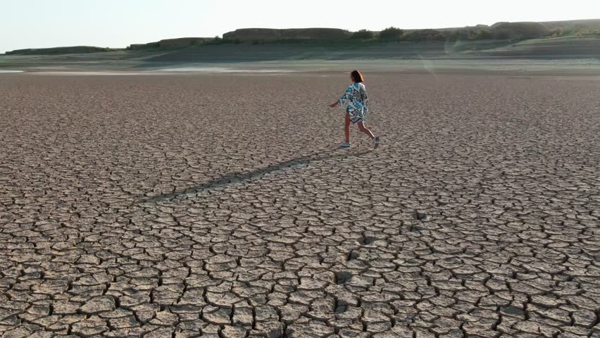 Shooting from a drone walking along a dried lake girl