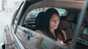 Video of beautiful young woman sending messages with her mobile phone in the car.