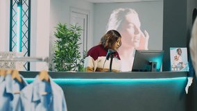 Asian client preparing to pay for clothes at cash register, talking to store assistant before buying modern merchandise. Young customer making purchase at pos terminal in clothing store. - Powered by Shutterstock - Get 15% off with code: PIKWIZARD15