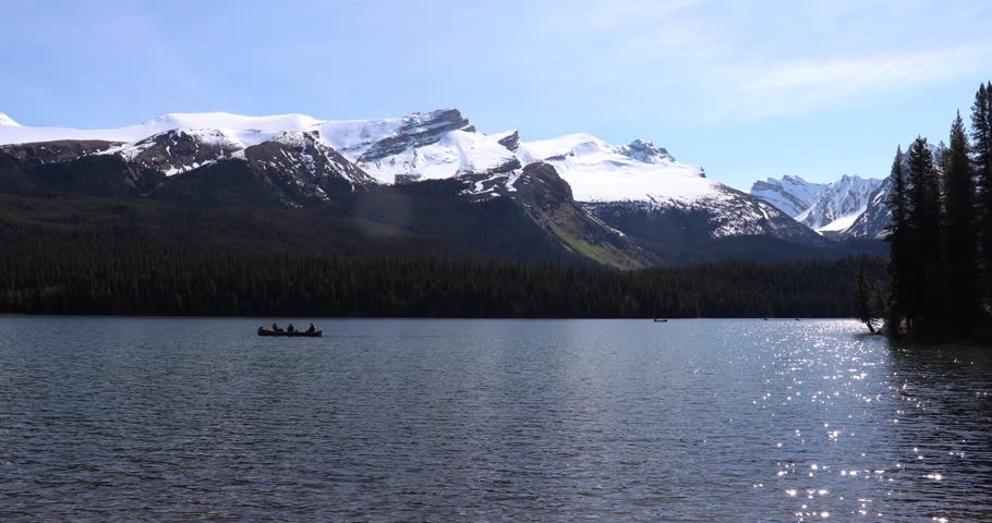 Summer landscape and people kayaking and fishing in Maligne lake, Jasper National Park, Canada
