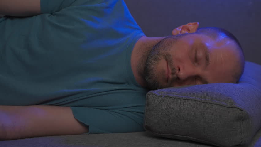 Tired man flops down on sofa and falls asleep. overworked man goes sleep on couch. exhausted man goes bed. end of hard working week or day concept. exhausted sleepy man lying asleep. sleeping person | Shutterstock HD Video #1101322417