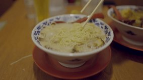 This video shows chopsticks taking a large bike of tonkatsu ramen noodles from a delicious bowl.