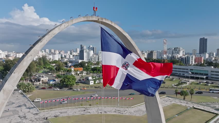 Dominican Republic National Flag Swaying With The Wind In Flag Square Of Santo Domingo, Dominican Republic - aerial, slow motion Royalty-Free Stock Footage #1101322949