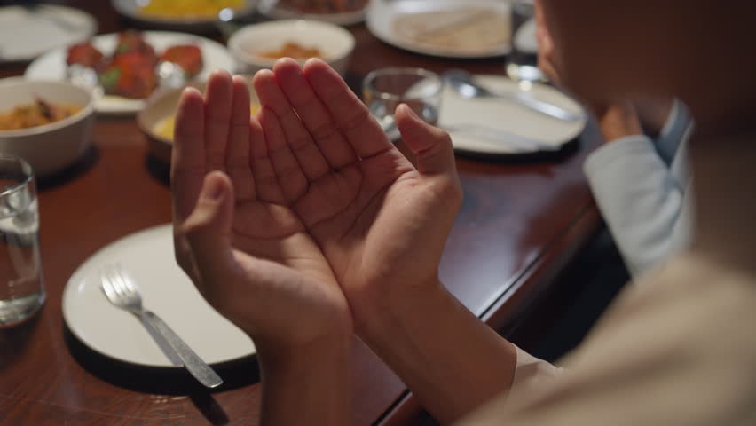 Close-up islam woman hand pray. Happy Asian muslim family praying to god before eating Ramadan dinner at home. Two generation celebration of Eid al-Fitr togetherness at home. Hari Raya family reunion. | Shutterstock HD Video #1101325429