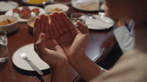 Close-up islam woman hand pray. Happy Asian muslim family praying to god before eating Ramadan dinner at home. Two generation celebration of Eid al-Fitr togetherness at home. Hari Raya family reunion.: stockvideo