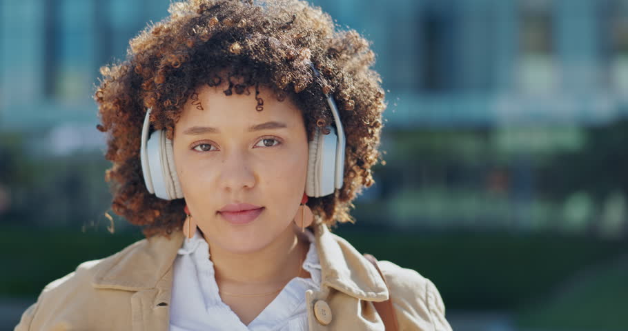 Portrait, music and woman remove headphones outdoors in a city or urban town while travel listening to a podcast. Audio, radio and face of a young person or cool female finish streaming a song