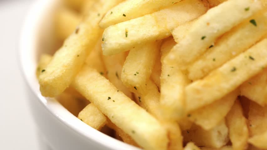 French fries background, closeup shot. Delicious Potato with golden fried crust rotating. French fries background. Potato straws rotate in a circle