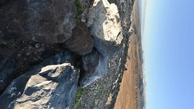 VERTICAL VIDEO, Rocky plateau, mountains in the distance on the island of Fuerteventura at sunrise