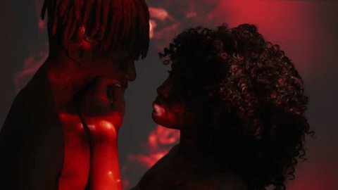 Love blossom. Beloved couple. Double exposure people. Sensual black man and woman looking each other posing on dark shadow red splashes overlay background. 庫存影片