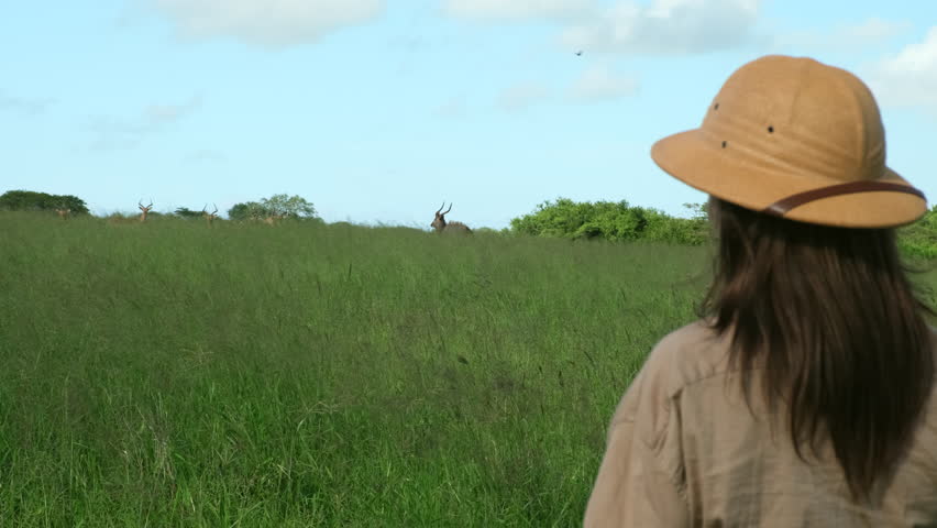 African women on vacation in the desert for travel, freedom and adventure. Walking, Woman on holiday at a safari during summer in nature of Kenya. a girl in a safari hat takes a photo in a safari park
