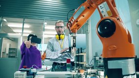 Virtual reality concept. Engineer is teaching a boy to manage a robotic arm - Powered by Shutterstock - Get 15% off with code: PIKWIZARD15